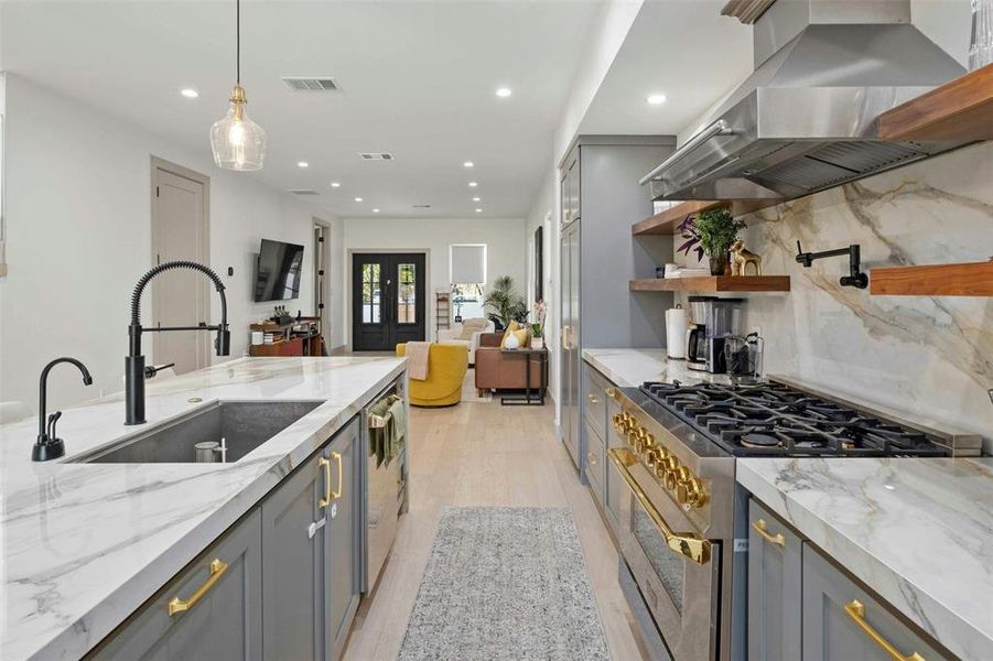 Shaker cabinetry with gold hardware provides ample storage space while adding a touch of luxury.