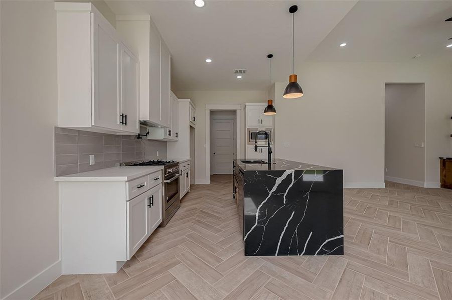 The waterfall countertop pulls this kitchen together. Your stovetop also features a 36in range.