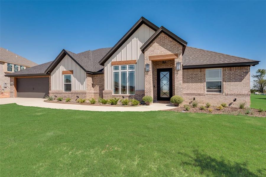 View of front of property featuring a garage and a front yard