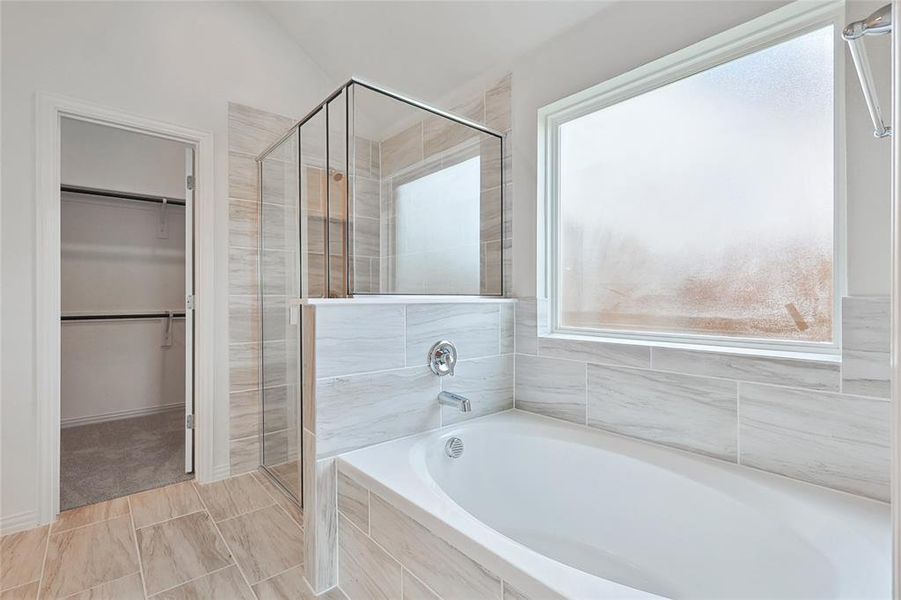 Bathroom with a healthy amount of sunlight, tile flooring, and shower with separate bathtub