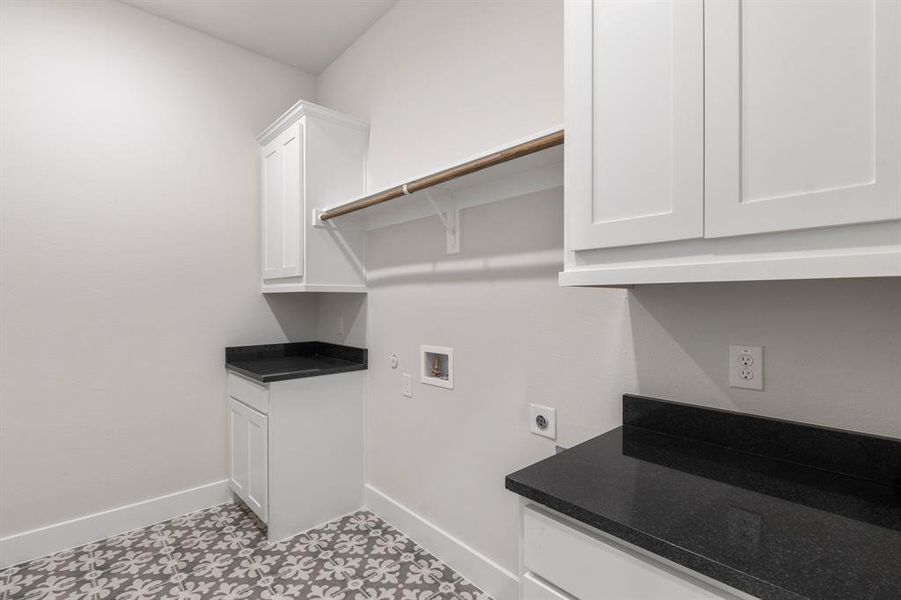 Laundry area featuring cabinets, electric dryer hookup, washer hookup, and light tile patterned floors