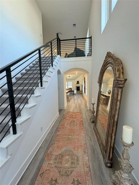 Entrance foyer featuring a towering ceiling and hardwood / wood-style flooring