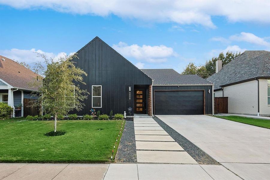 View of front of house featuring a front yard and a garage