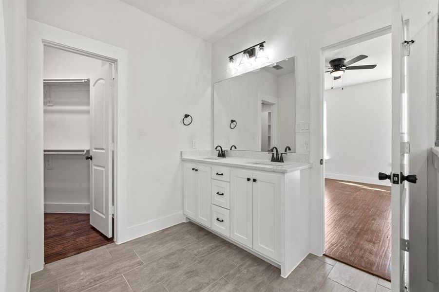 Bathroom with wood-type flooring, ceiling fan, and vanity