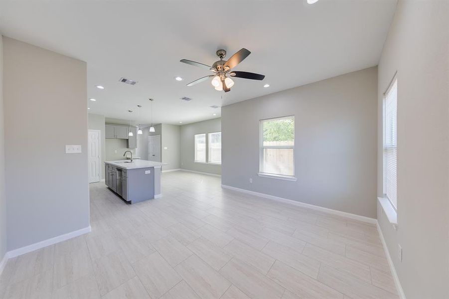 This shot beautifully showcases the open-concept layout, emphasizing the seamless flow between the living room, dining area, and kitchen. The spacious design creates an inviting environment that encourages interaction and togetherness. With ample room for movement and natural light streaming in, this layout enhances both comfort and functionality, making it perfect for everyday living and entertaining.