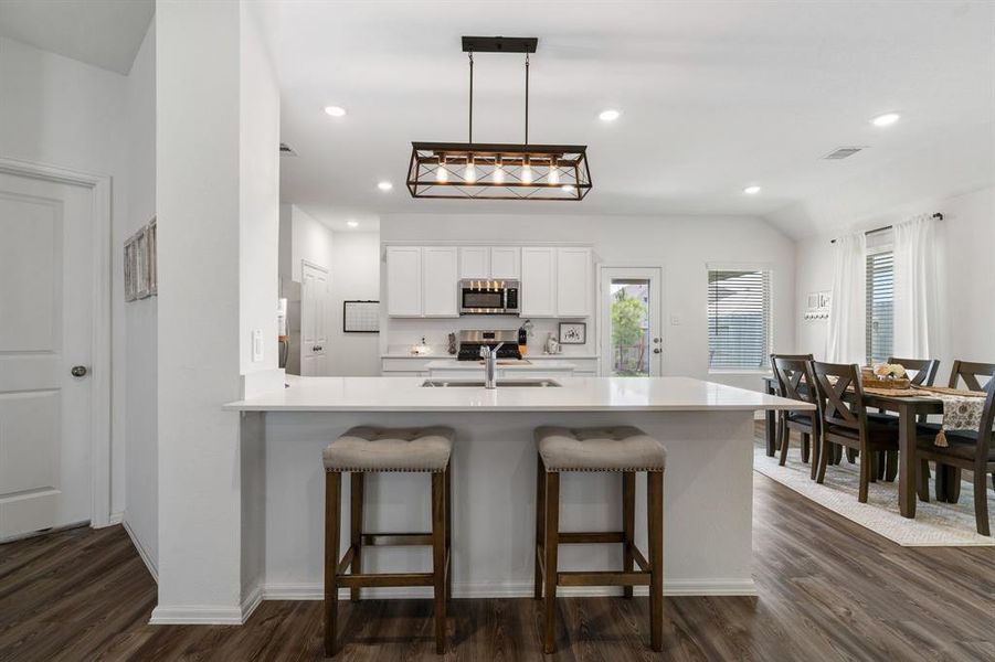 Kitchen has breakfast bar, island and an abundance of cabinets.