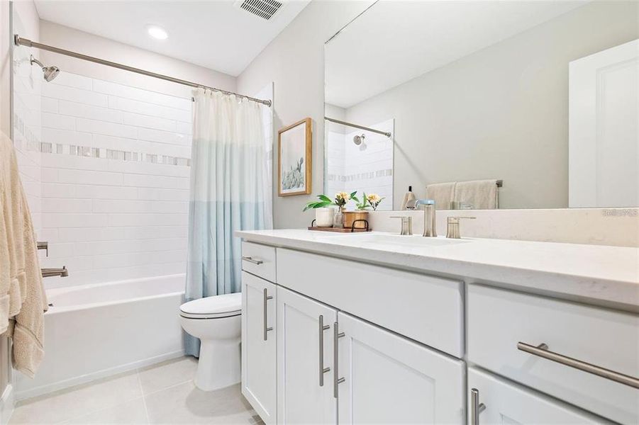 Two of the bedrooms on the second level share this bathroom with a large vanity and bathtub.