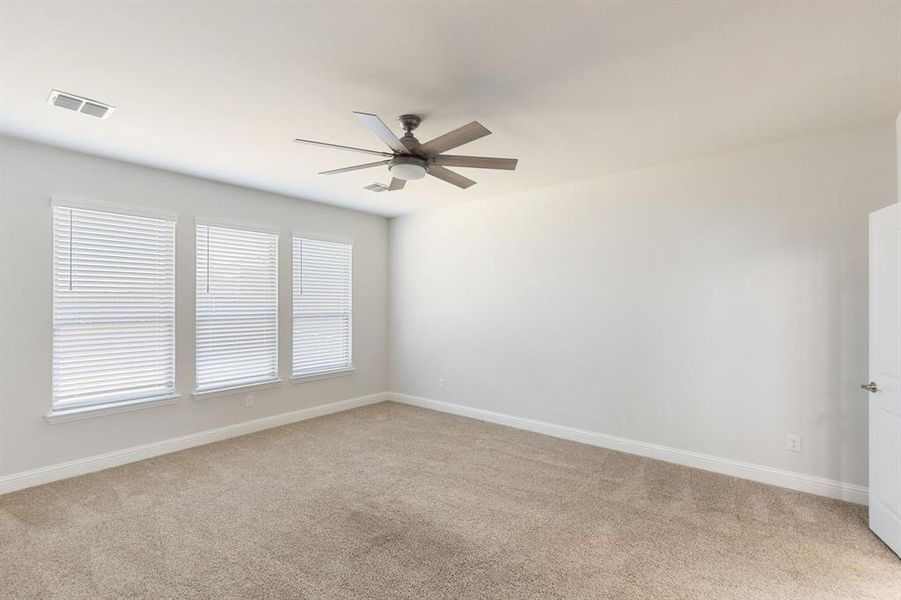 Empty room featuring carpet flooring and ceiling fan