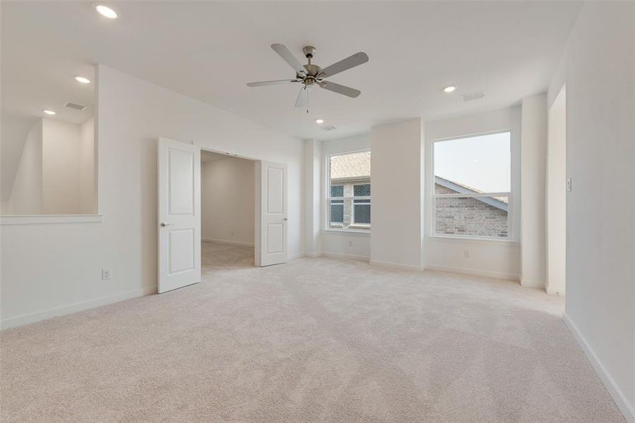 Carpeted empty room featuring ceiling fan