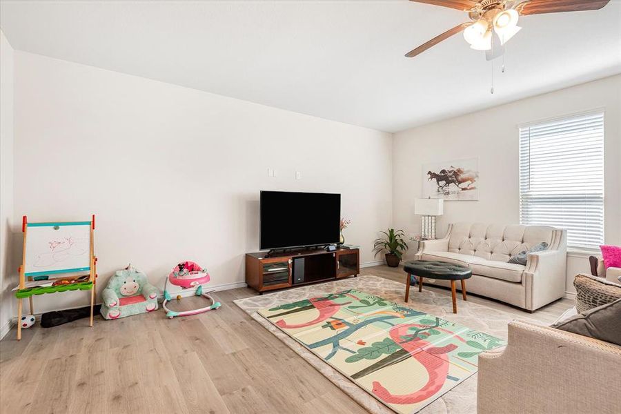 Living room featuring light hardwood / wood-style floors and ceiling fan