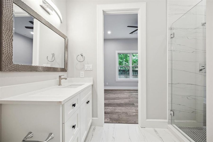 The en-suite bathroom with glass enclosed shower on level one