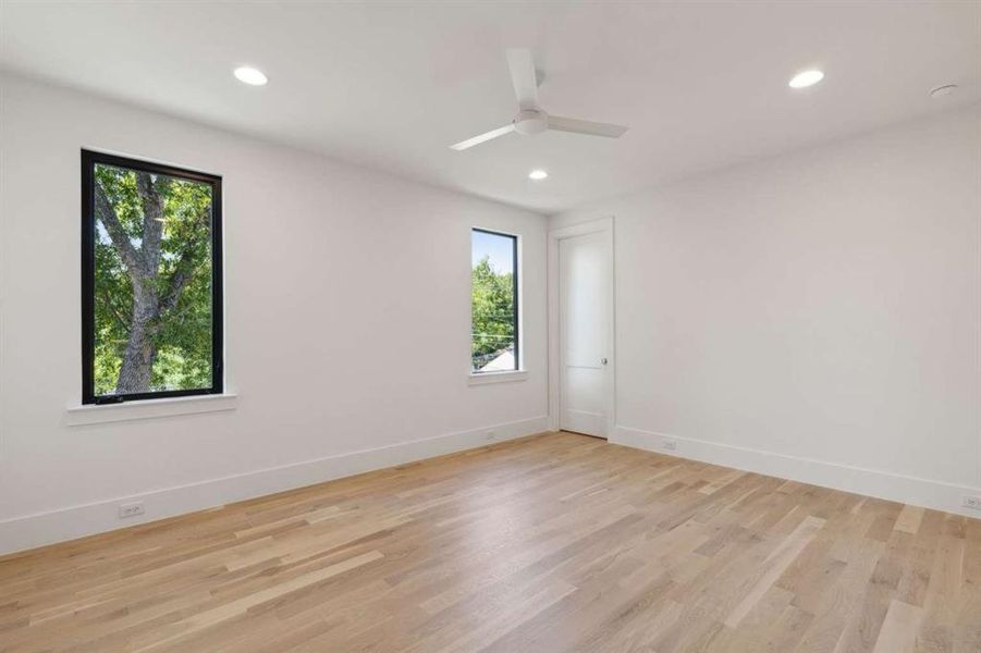 Empty room with light hardwood / wood-style floors, ceiling fan, and plenty of natural light