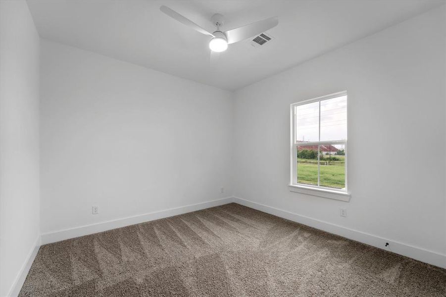 Another bedroom located upstairs, offering plush carpet and a ceiling fan.