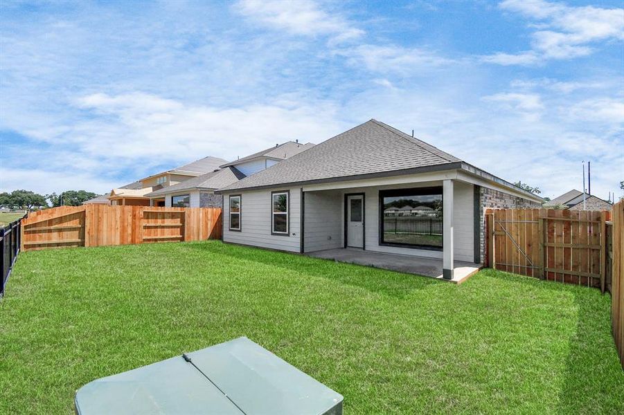 Explore the expansive backyard with its inviting covered patio—a perfect blend of space for the kids to play and adults to unwind. Sample photo of completed home. As-built color and selections may vary.