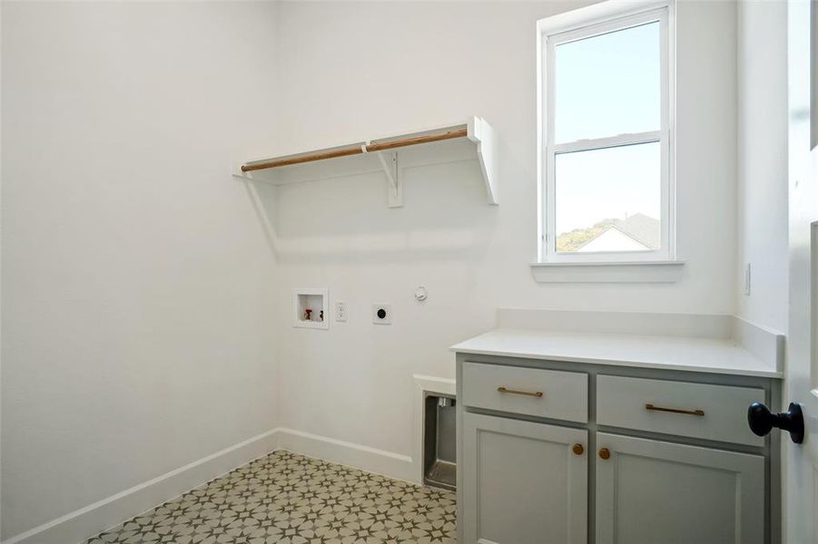 Washroom with hookup for a washing machine, electric dryer hookup, and cabinets