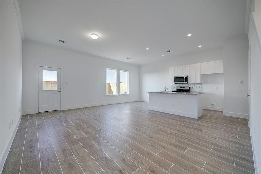 Guests are welcomed by wood-like tile flooring that extends througout the living areas, enhacing the home's durability. 10ft ceilings are decorated with crown moldiing throughout the living areas.