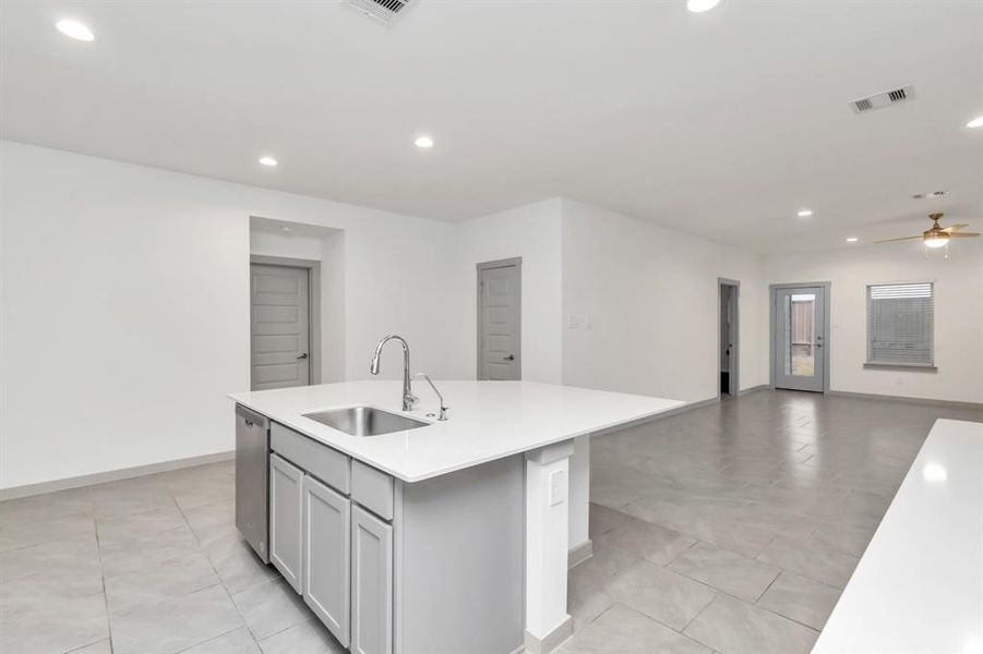 Spacious kitchen with grey modern cabinets and quartz counterspace. A lot of cabinets are given for extra storage