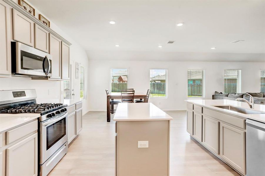 THIS KITCHEN IS THE HEART OF THE HOME AND FEATURES AN ISLAND, EXPANSIVE COUNTER SPACE AND A BREAKFAST AREA PROVIDES ADDITIONAL SEATING.