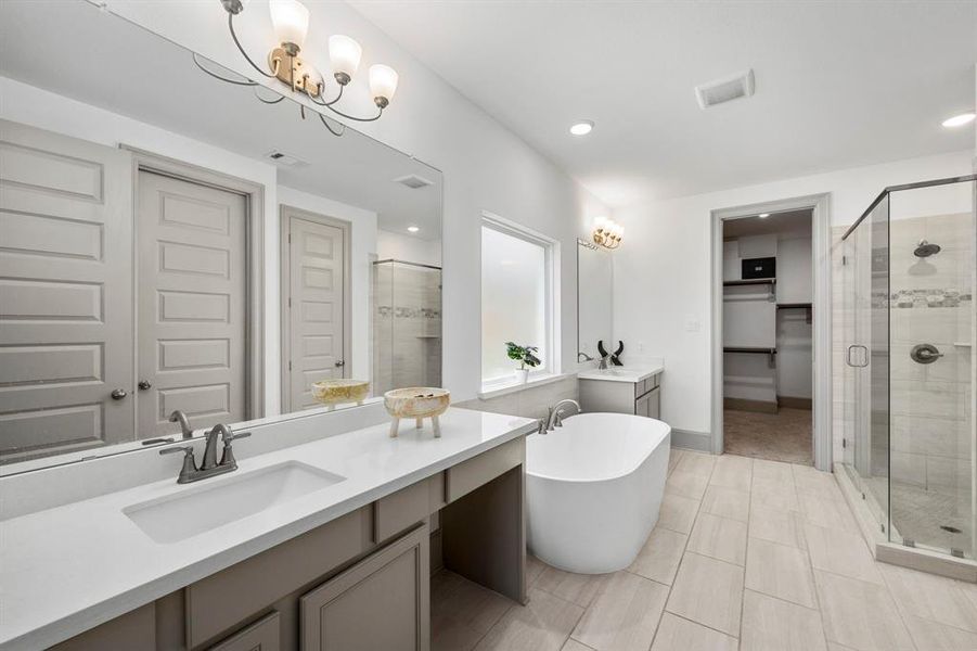 Primary bathroom has dual vanities and gives everyone space to get ready.