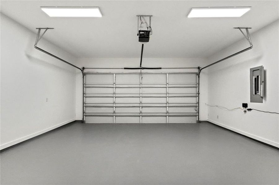 Garage featuring a garage door opener and electric panel