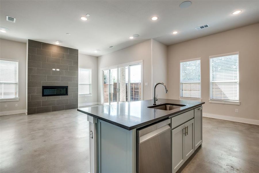 Kitchen with a wealth of natural light, sink, and a kitchen island with sink