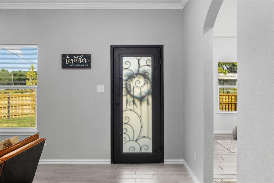 Foyer featuring light hardwood / wood-style flooring and ornamental molding