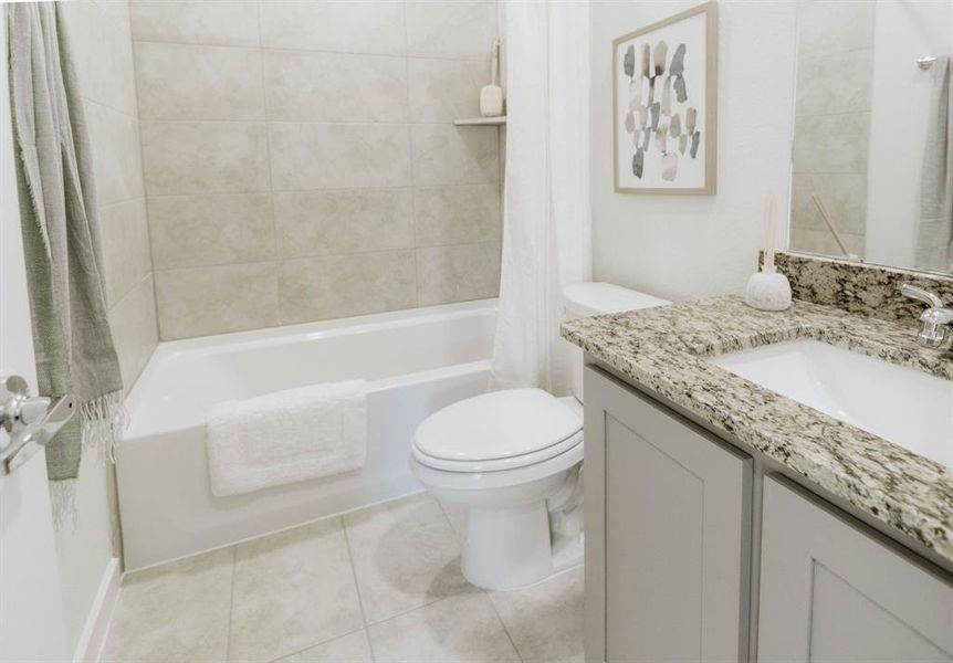 Full bathroom with shower / tub combo, tile patterned flooring, vanity, and toilet