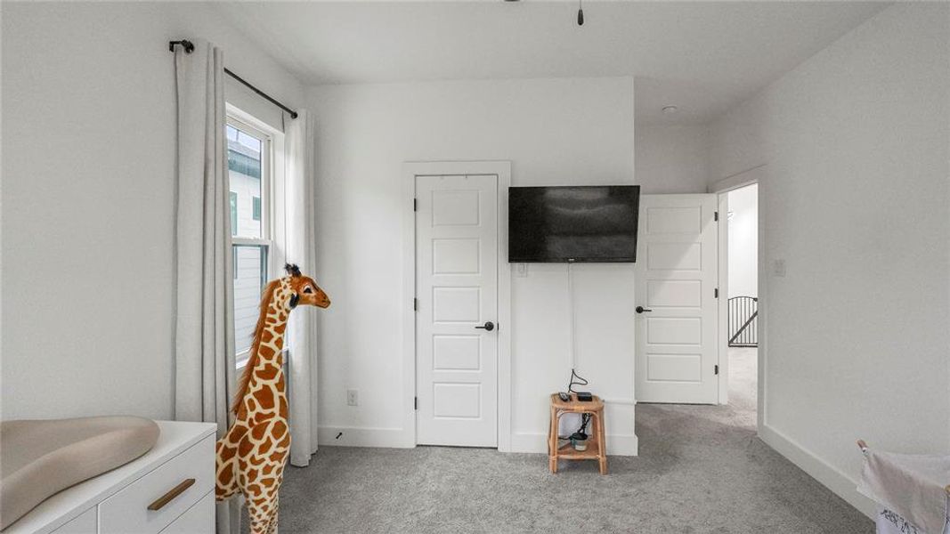 Bedroom featuring light colored carpet