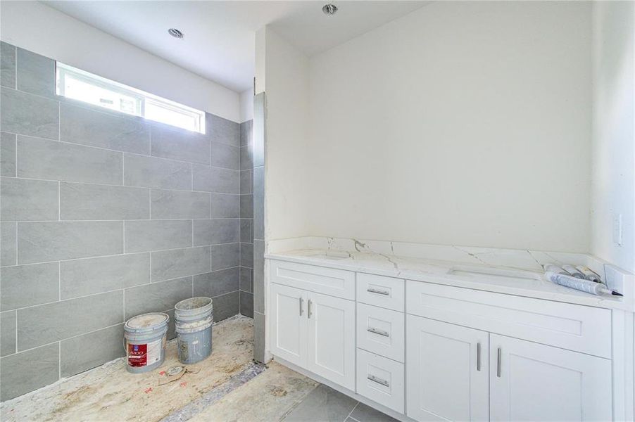 This bathroom is awaiting your finishing touches. Featuring a spacious shower with contemporary tile work and a sleek vanity, it’s designed to be both functional and stylish. Imagine unwinding in this serene space, tailored to your personal preferences. **This image is from another Saratoga Home - Artemis floorplan.**