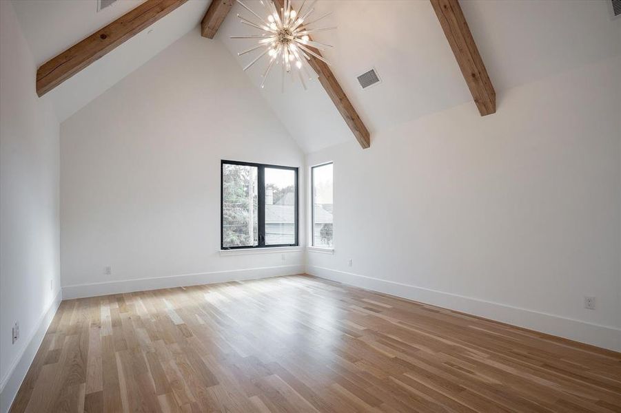 Spare room featuring light wood-type flooring, beamed ceiling, high vaulted ceiling, and an inviting chandelier