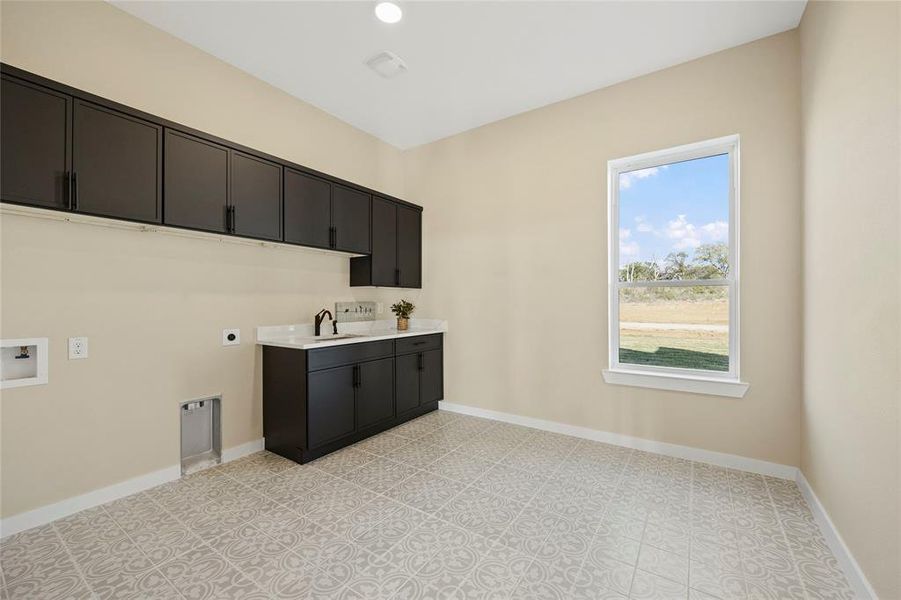 Washroom with cabinets, hookup for an electric dryer, sink, and washer hookup