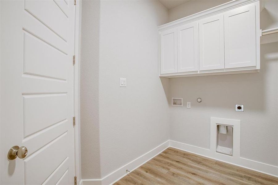 Laundry room featuring hookup for a gas dryer, cabinets, light hardwood / wood-style flooring, electric dryer hookup, and washer hookup