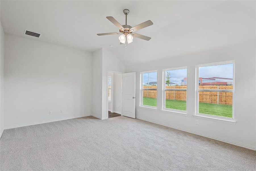 Unfurnished room featuring vaulted ceiling, ceiling fan, and light colored carpet