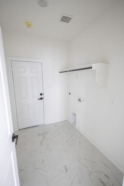 Laundry area with washer hookup, hookup for an electric dryer, hookup for a gas dryer, and light tile floors