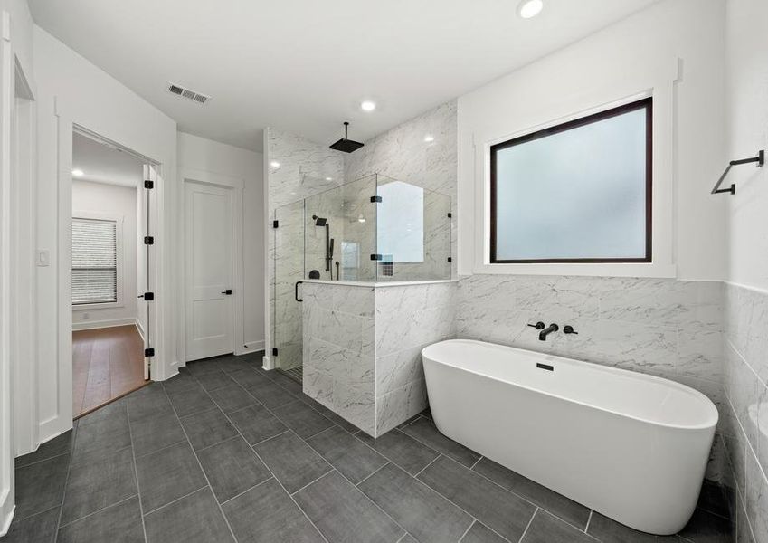 The gorgeous master bathroom has a large glass, walk-in shower and tub.