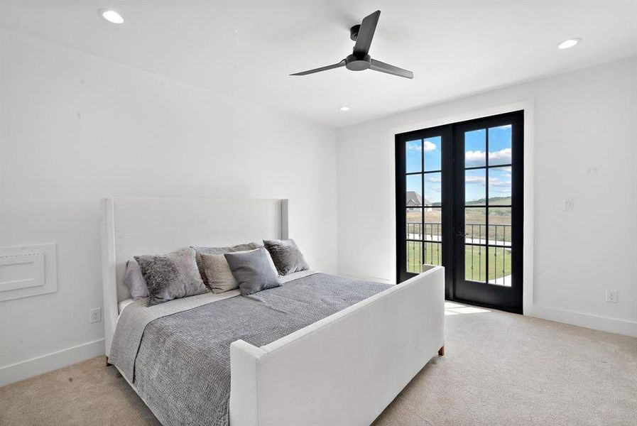 Carpeted bedroom featuring ceiling fan, multiple windows, access to exterior, and french doors