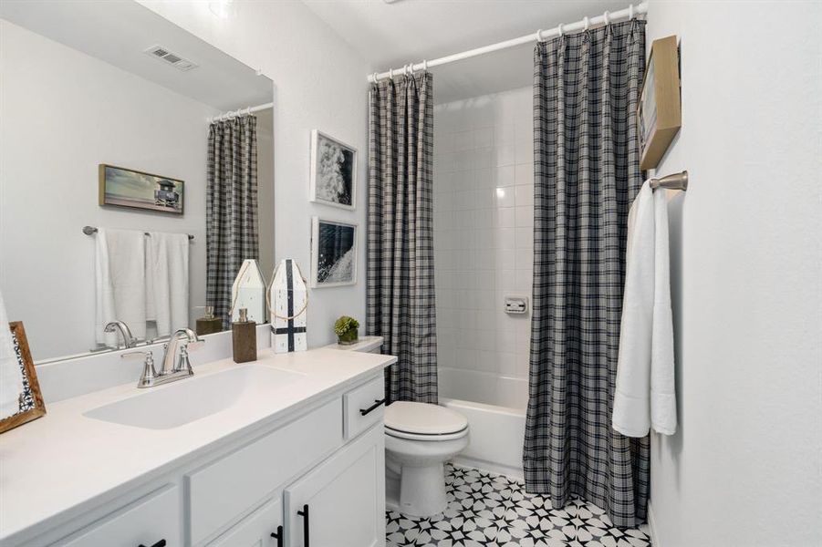 Full bathroom featuring toilet, shower / bath combo with shower curtain, and vanity