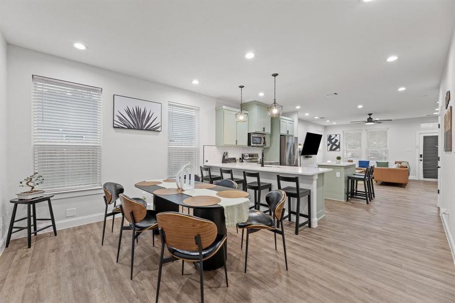 Dining room with a wealth of natural light, light wood-type flooring, and ceiling fan