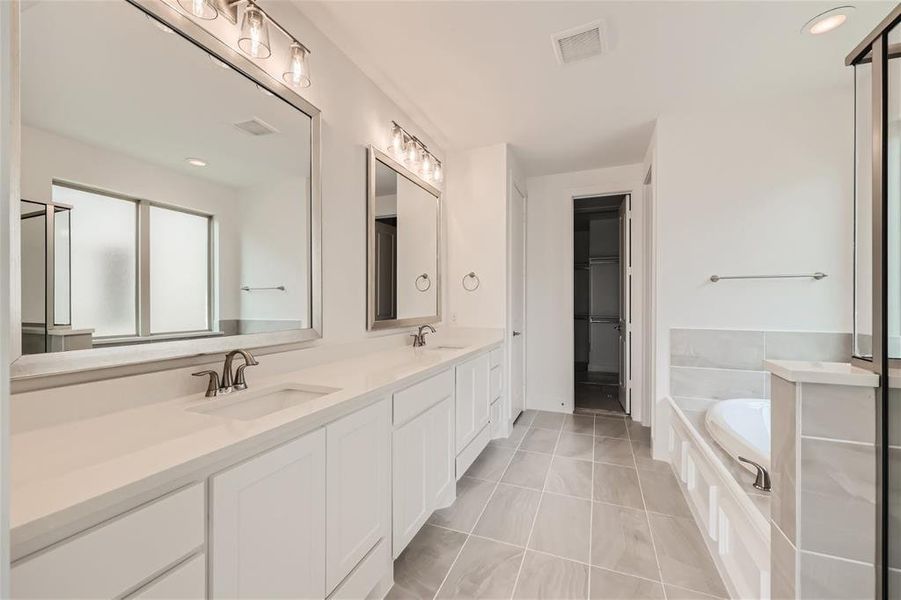 Bathroom featuring tile floors, a bathtub, and double sink vanity