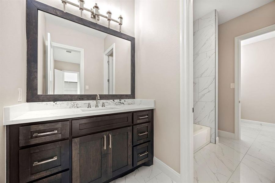 Bathroom featuring tile patterned flooring, vanity, and tiled shower / bath