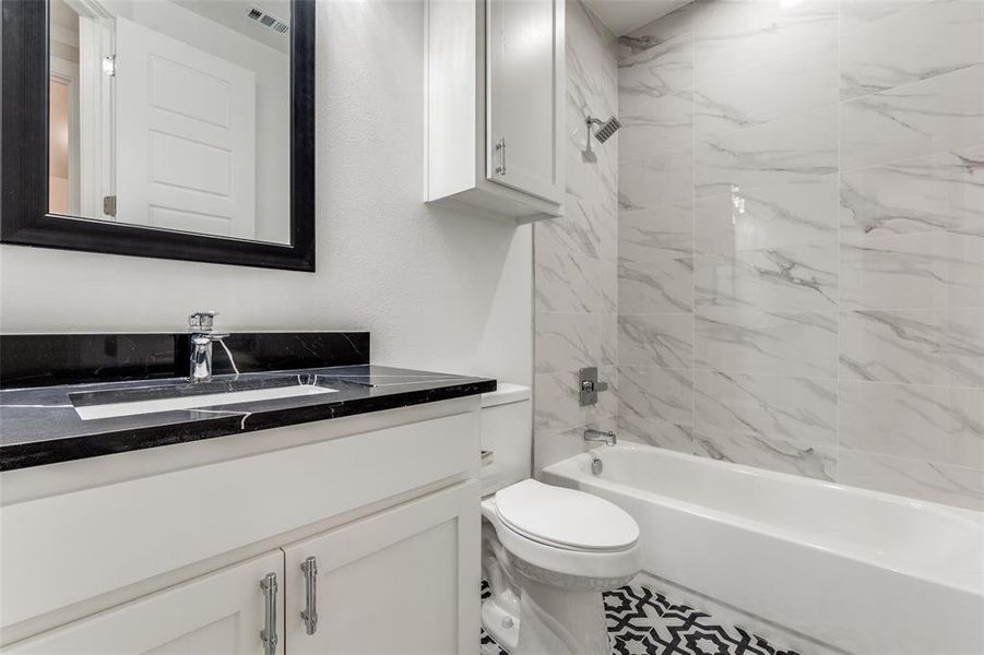 Upgraded bathroom with floor to ceiling tiles.