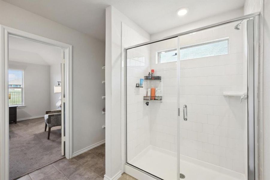 Bathroom featuring a wealth of natural light, tile patterned floors, and an enclosed shower