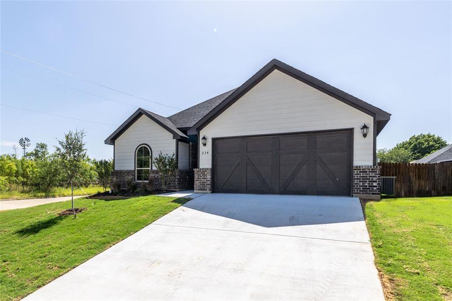 View of front of property featuring a garage and a front yard