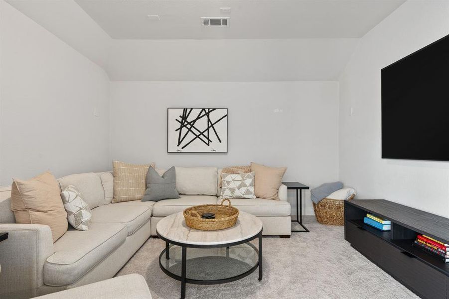 Living room with light carpet and vaulted ceiling