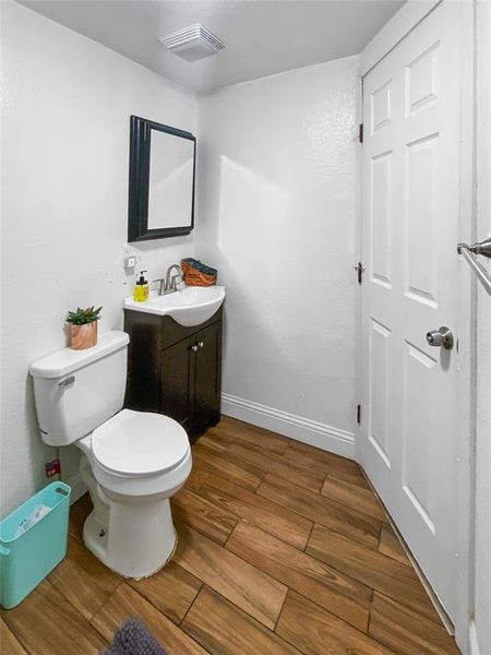 Bathroom featuring hardwood / wood-style floors, vanity, and toilet