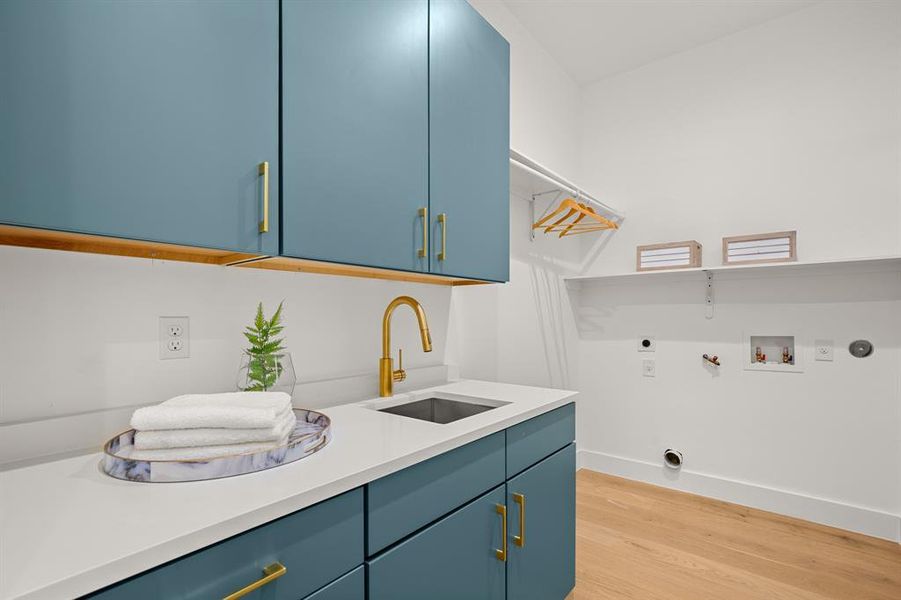 The spacious in home laundry room comes with beautiful contemporary storage cabinetry with a folding vanity and sink.