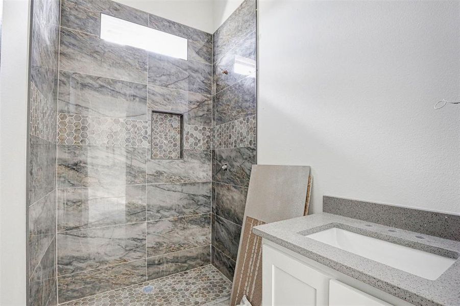 Bathroom with vanity, tile patterned flooring, and tiled shower / bath combo