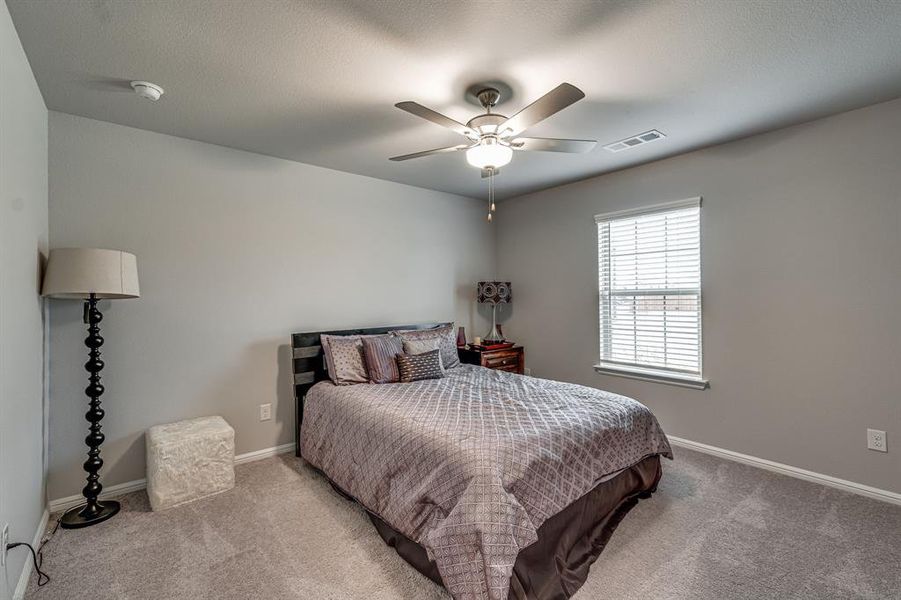 Carpeted bedroom featuring ceiling fan