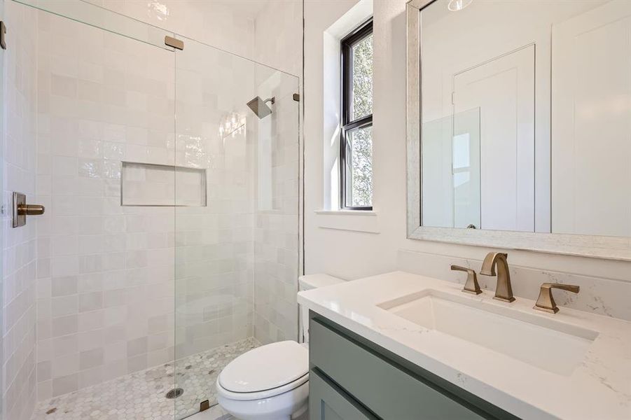 Bathroom featuring walk in shower, toilet, and vanity