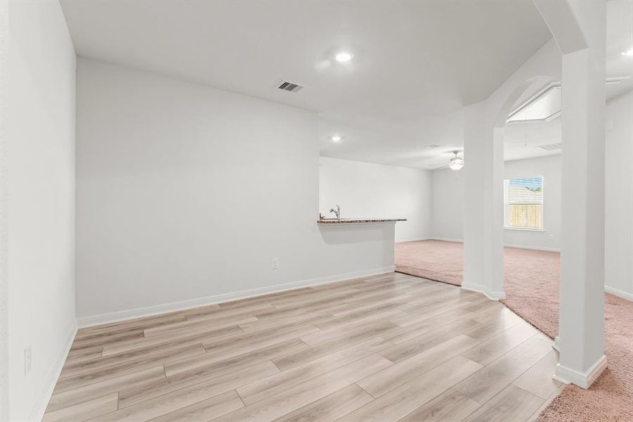 The Dining room is perfect for large family gatherings or formal dinners.  This room exudes elegance with its warm wood-look vinyl plank flooring, arched entryways, and clean recessed lighting.